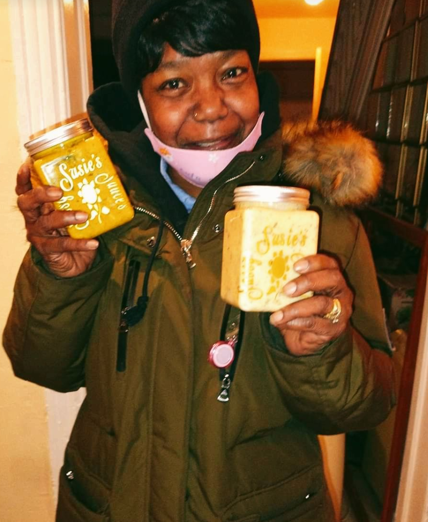 Woman holding Sassy Susie's peanut butter jars