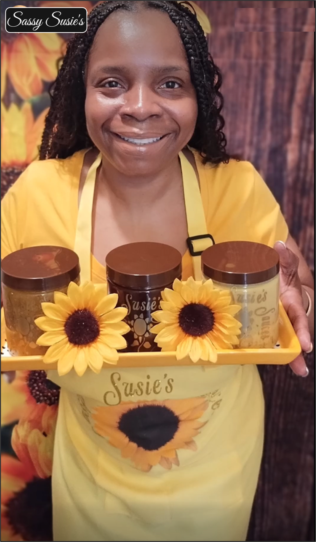 Tia Dandy holding a tray of Sassy Susie's sauce jars
